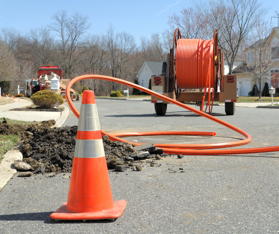 fiber optics on a roll being installed near an orange cone